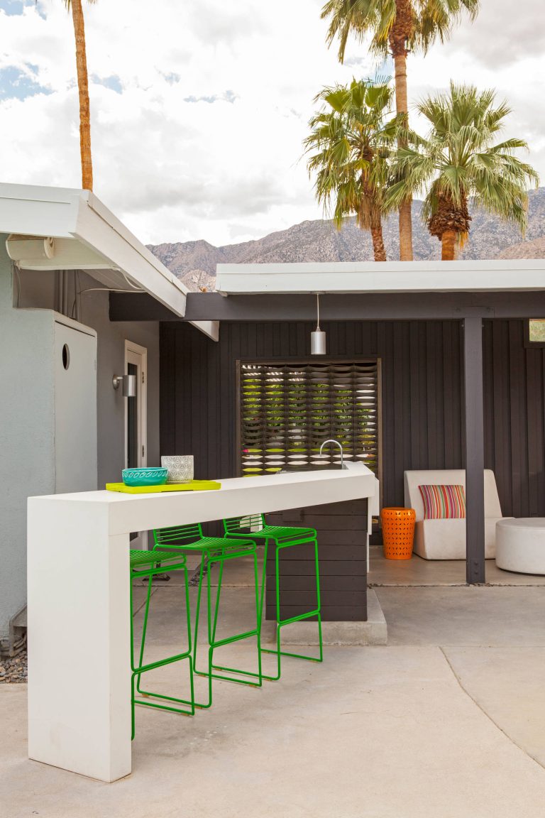Patio kitchen - 1960s concrete paver patio kitchen idea in Other with a roof extension