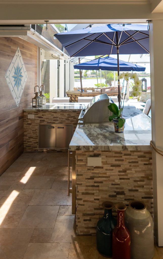 Patio kitchen - backyard stone patio kitchen idea in Miami with a roof extension