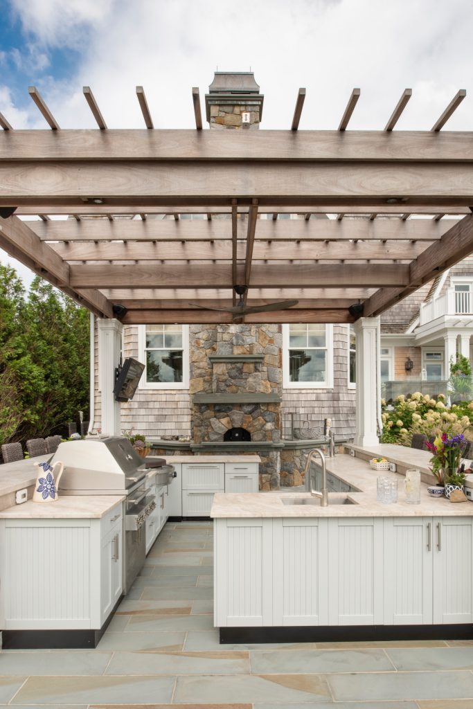 Patio kitchen - coastal tile patio kitchen idea in New York with a pergola