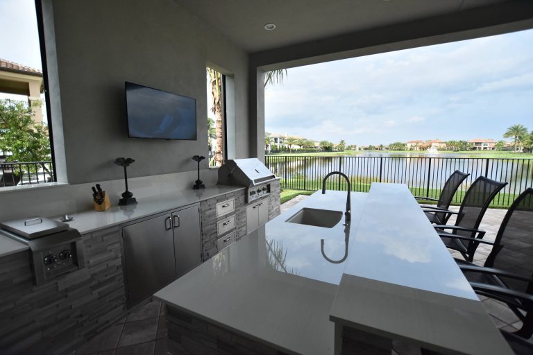 Patio kitchen - contemporary backyard concrete paver patio kitchen idea in Miami with a roof extension
