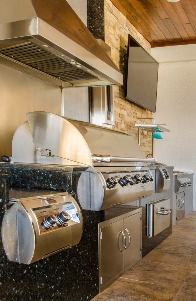 Patio kitchen - huge contemporary backyard stone patio kitchen idea in Tampa with a roof extension