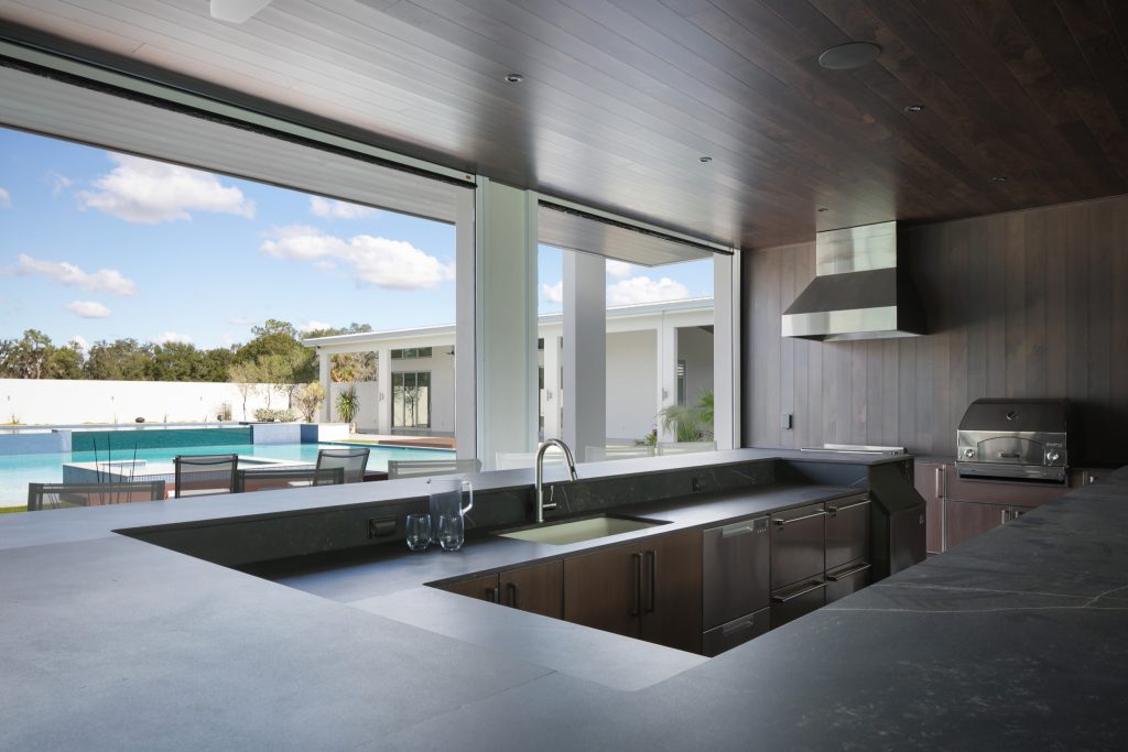 Patio kitchen - huge contemporary courtyard tile patio kitchen idea in Tampa with a roof extension
