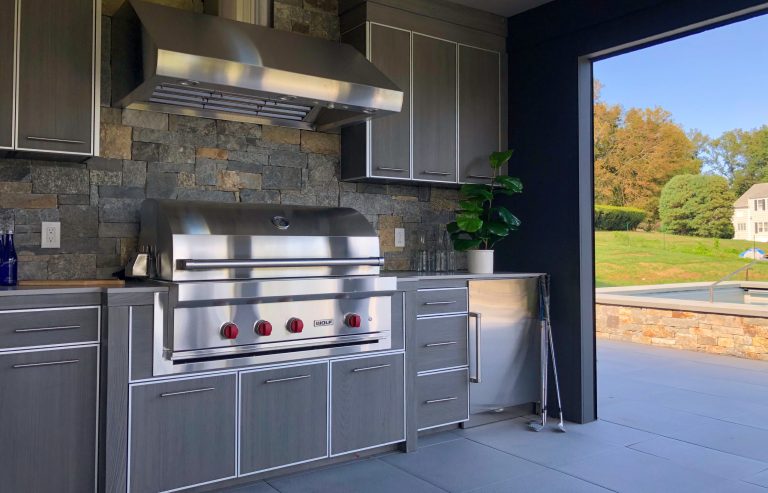 Patio kitchen - huge contemporary side yard concrete paver patio kitchen idea in New York with a roof extension