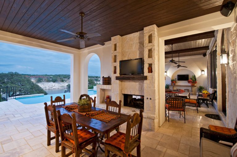 Patio kitchen - huge mediterranean backyard stone patio kitchen idea in Austin with a roof extension