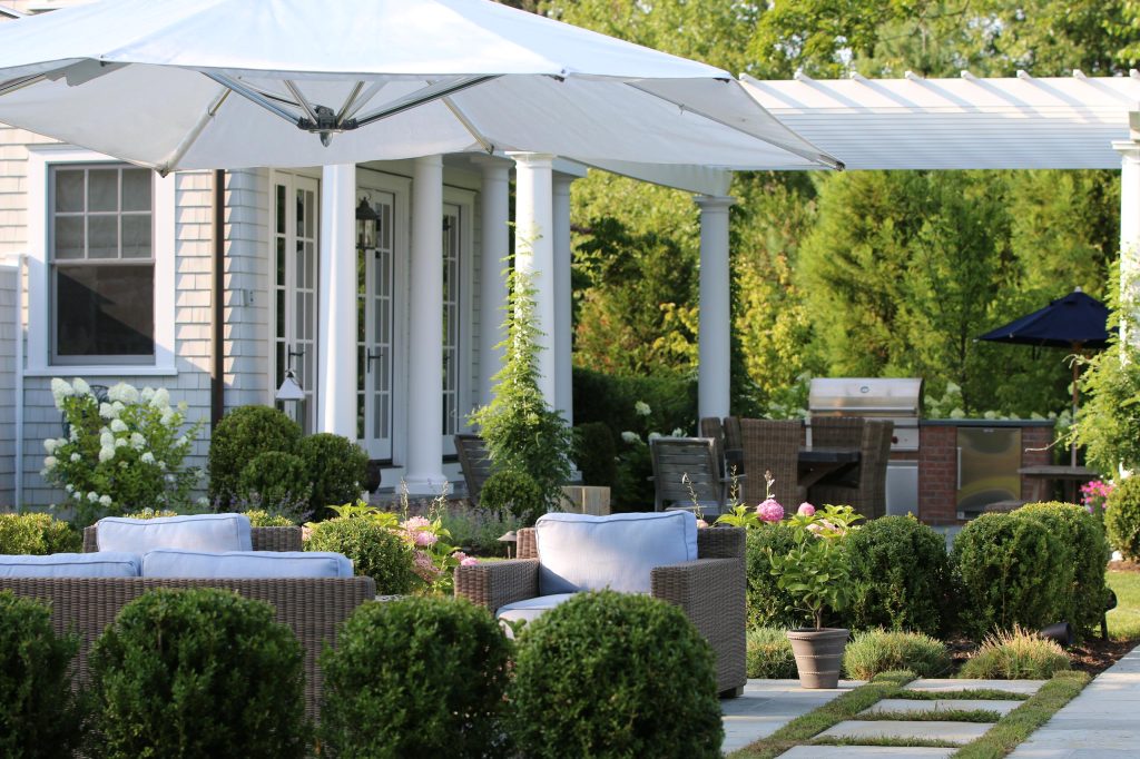 Patio kitchen - huge traditional backyard stone patio kitchen idea in New York with a pergola