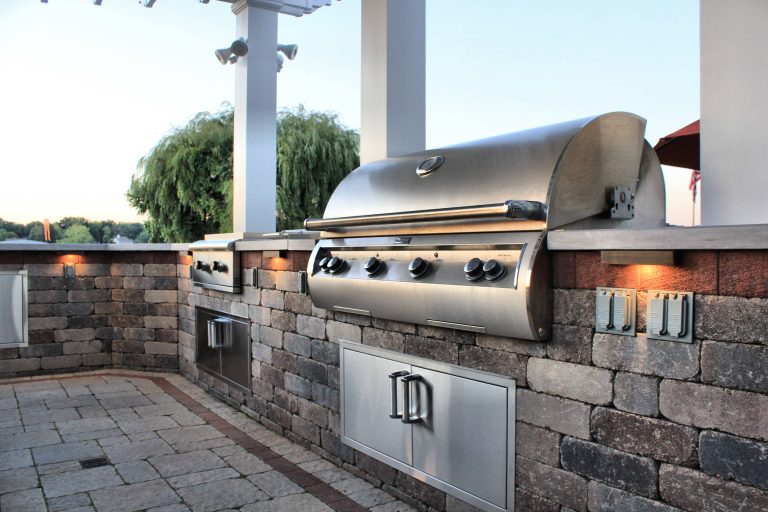Patio kitchen - large backyard brick patio kitchen idea in Other with a pergola