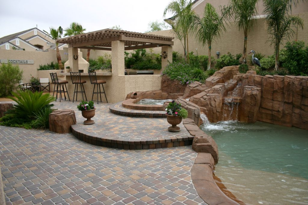 Patio kitchen - large backyard stone patio kitchen idea in Las Vegas with no cover