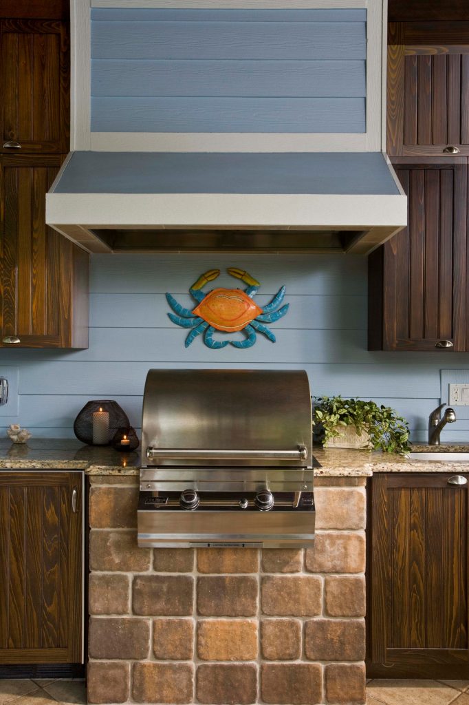 Patio kitchen - large coastal backyard concrete paver patio kitchen idea in Miami with a roof extension