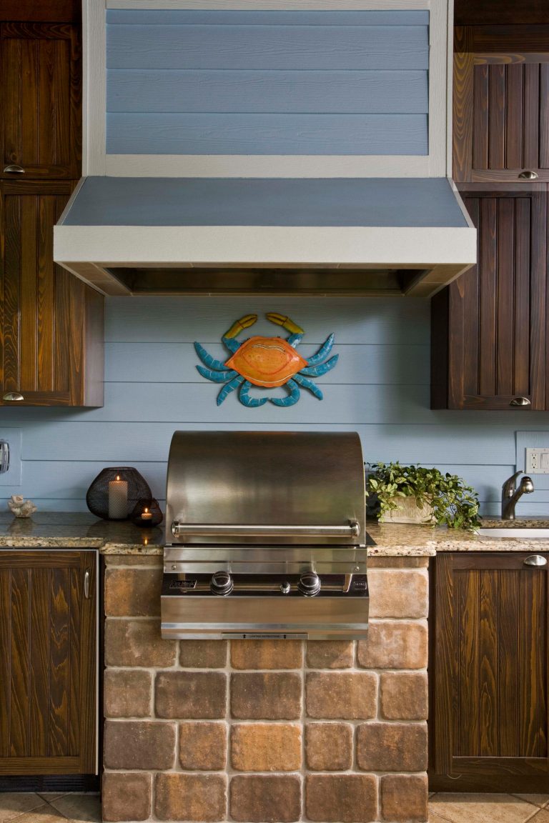 Patio kitchen - large coastal backyard concrete paver patio kitchen idea in Miami with a roof extension
