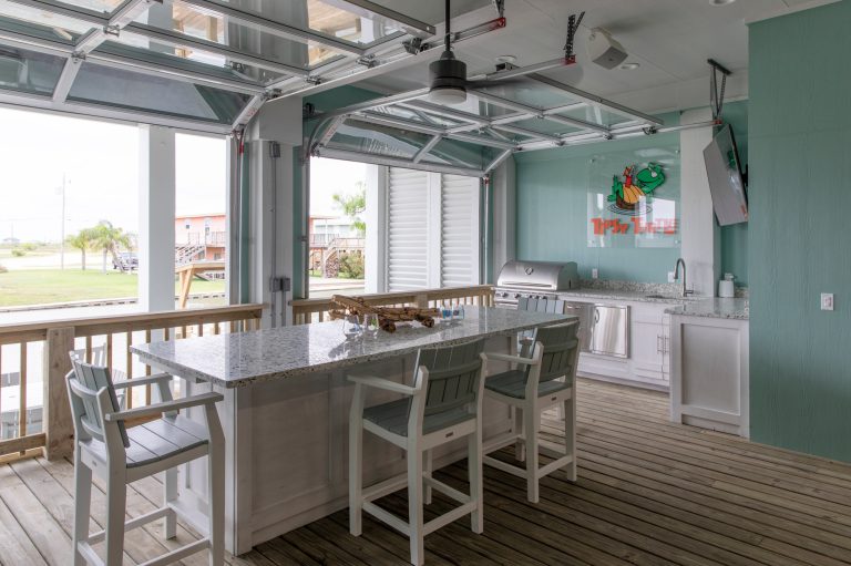 Patio kitchen - large coastal backyard patio kitchen idea in Houston with decking and a roof extension