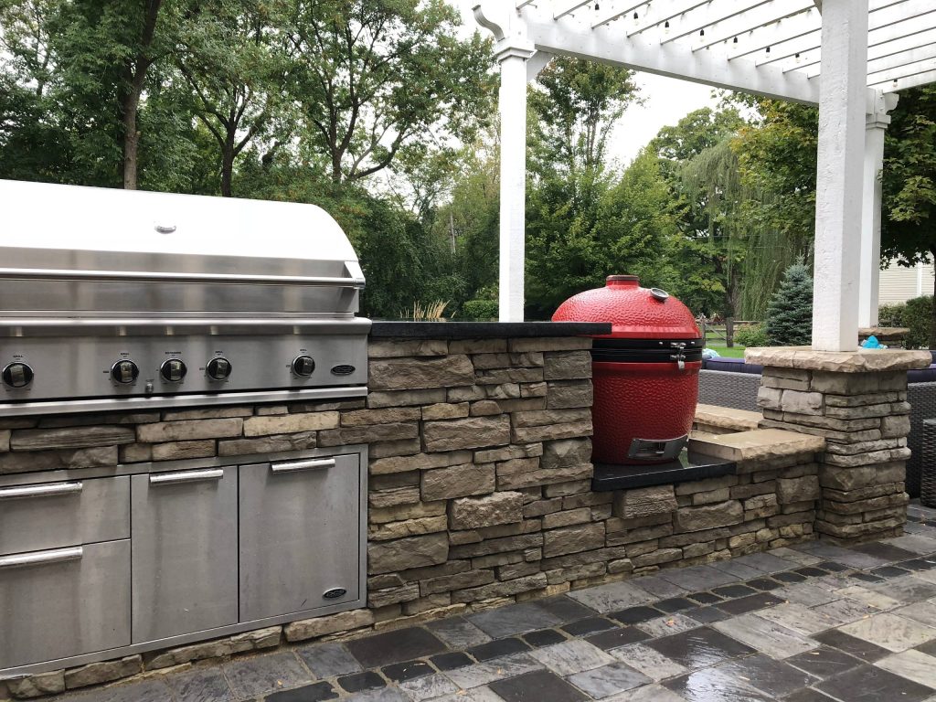 Patio kitchen - large contemporary backyard brick patio kitchen idea in Chicago with a pergola