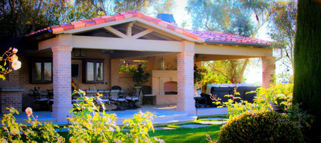 Patio kitchen - large contemporary backyard brick patio kitchen idea in Orange County with a pergola