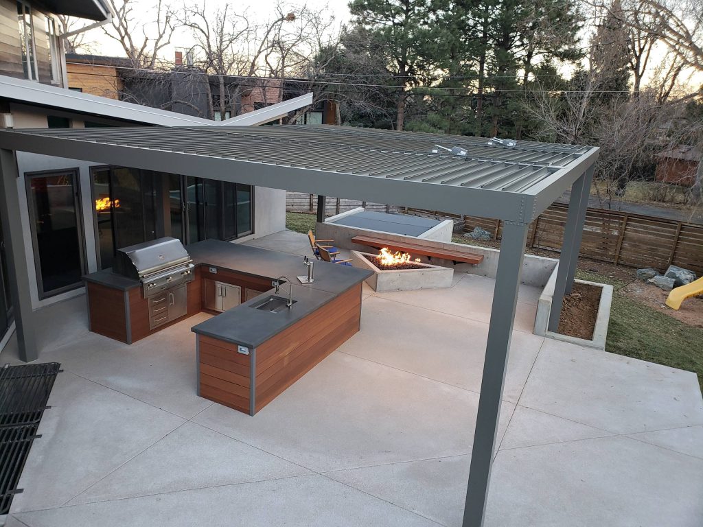 Patio kitchen - large contemporary backyard concrete patio kitchen idea in Denver with a pergola