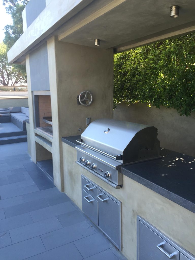 Patio kitchen - large contemporary backyard concrete paver patio kitchen idea in Los Angeles
