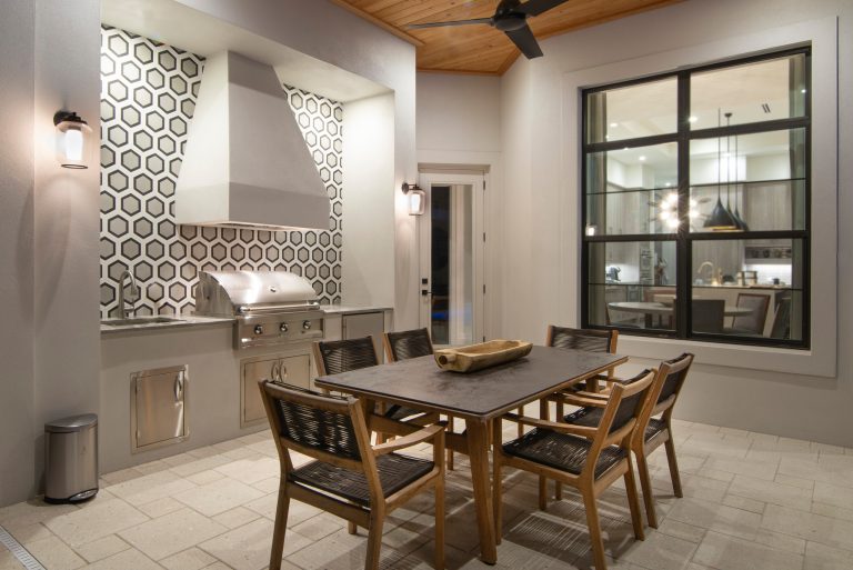 Patio kitchen - large contemporary backyard concrete paver patio kitchen idea in Miami with a roof extension