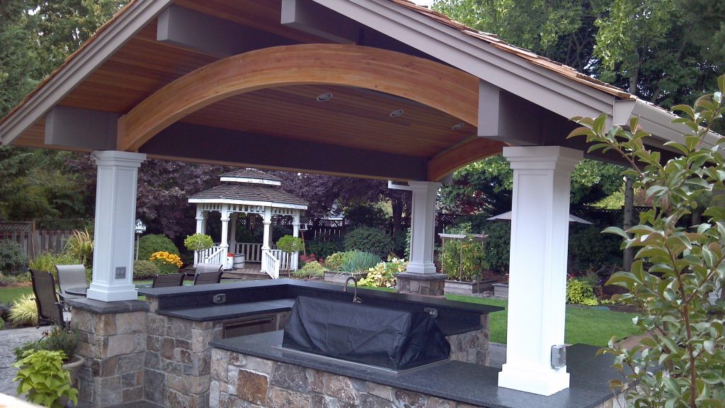 Patio kitchen - large contemporary backyard stamped concrete patio kitchen idea in Portland with a roof extension