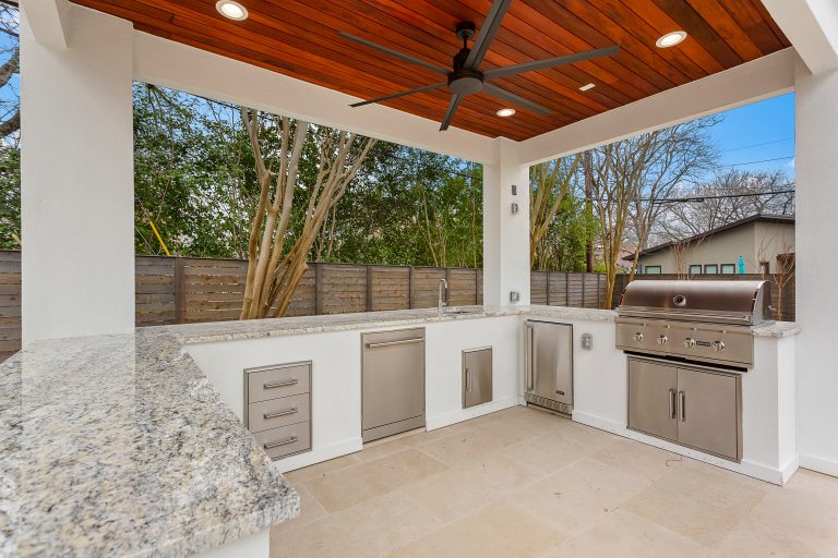 Patio kitchen - large contemporary backyard stone patio kitchen idea in Austin with a gazebo