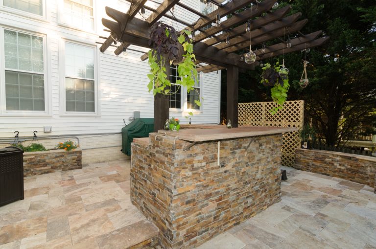 Patio kitchen - large contemporary backyard stone patio kitchen idea in Baltimore with a pergola