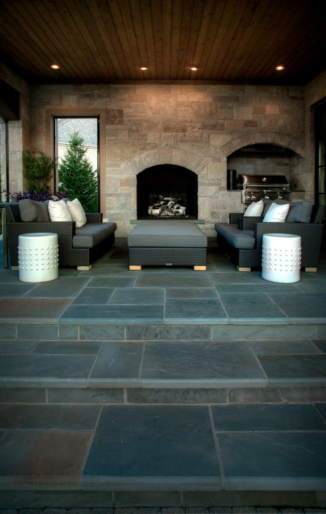 Patio kitchen - large contemporary backyard stone patio kitchen idea in Detroit with a roof extension