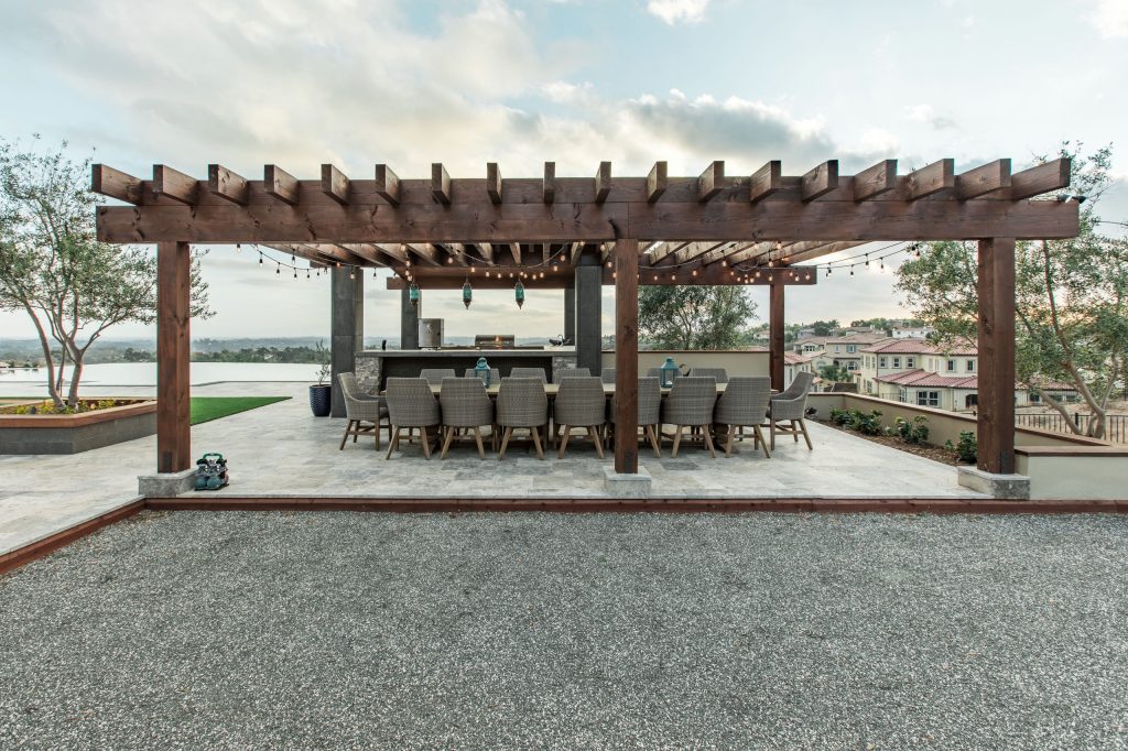 Patio kitchen - large contemporary backyard stone patio kitchen idea in San Diego with a pergola