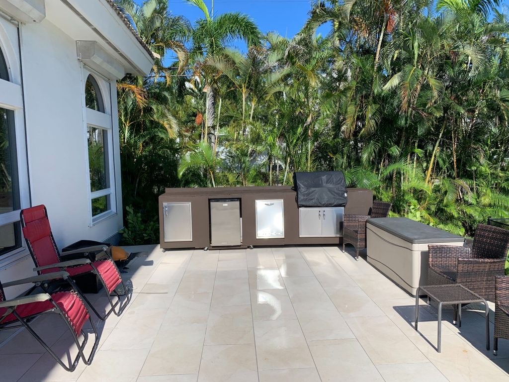 Patio kitchen - large contemporary backyard tile patio kitchen idea in Miami with a pergola