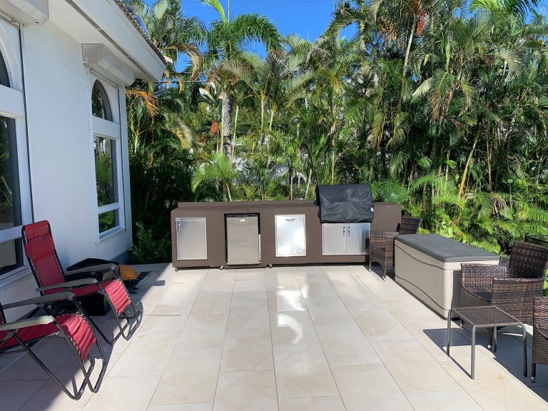 Patio kitchen - large contemporary backyard tile patio kitchen idea in Miami with a pergola