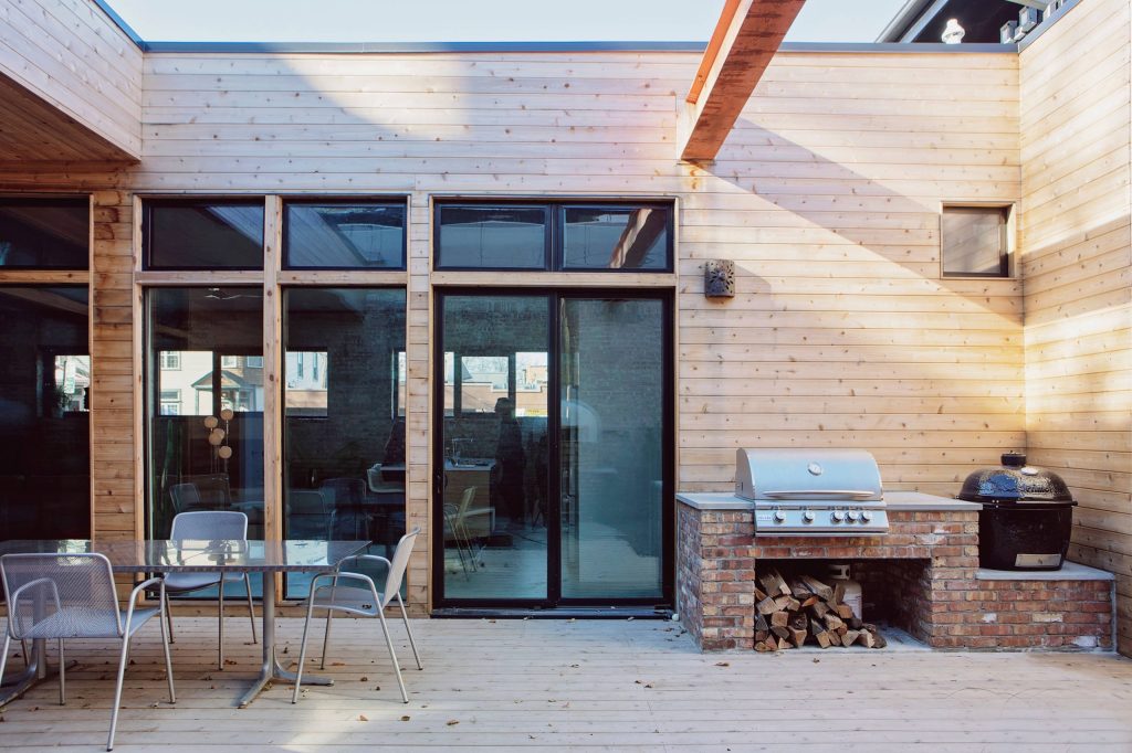 Patio kitchen - large contemporary courtyard stone patio kitchen idea in Chicago with no cover