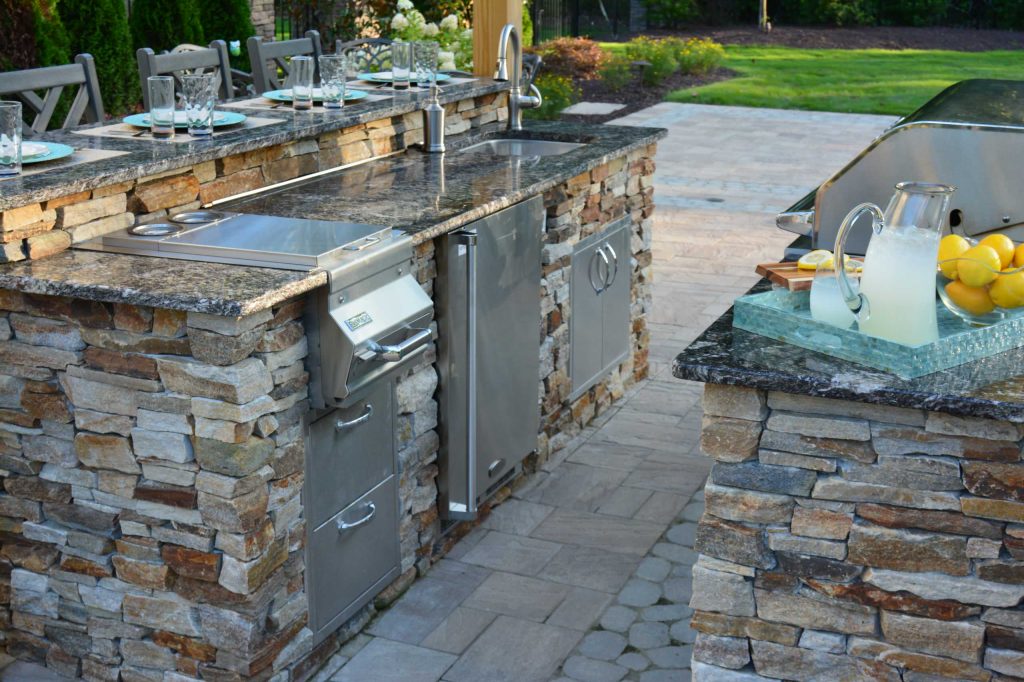 Patio kitchen - large craftsman backyard concrete paver patio kitchen idea in Richmond with a pergola