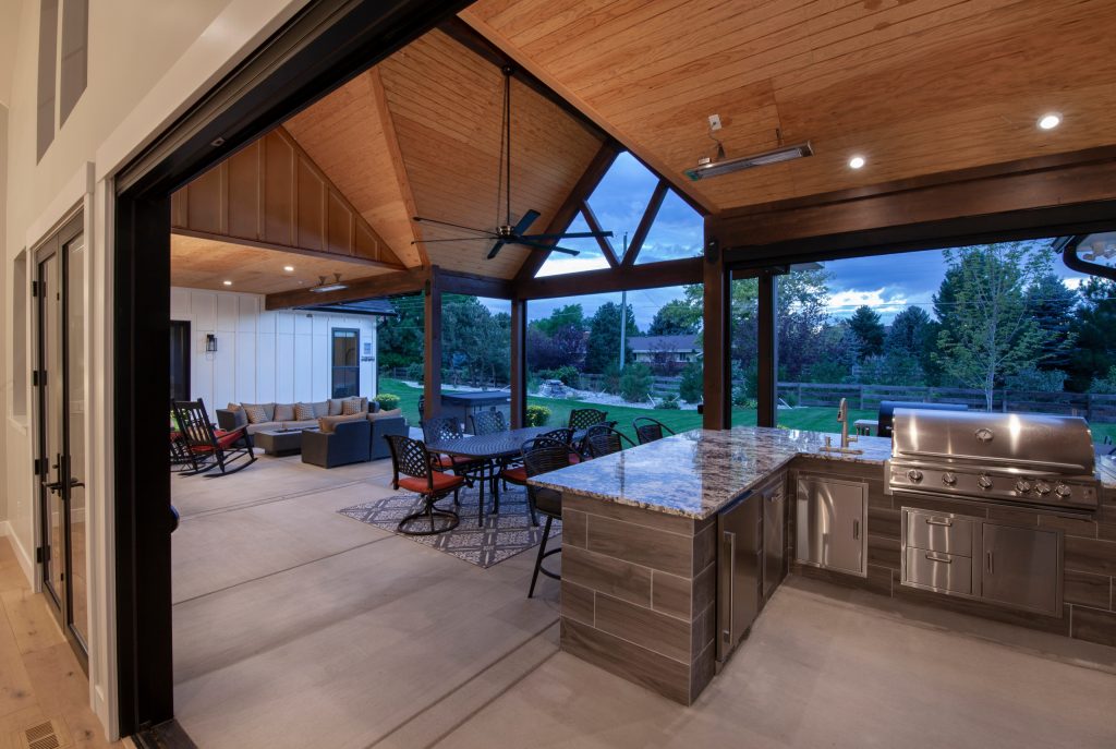 Patio kitchen - large farmhouse backyard concrete patio kitchen idea in Denver with a roof extension
