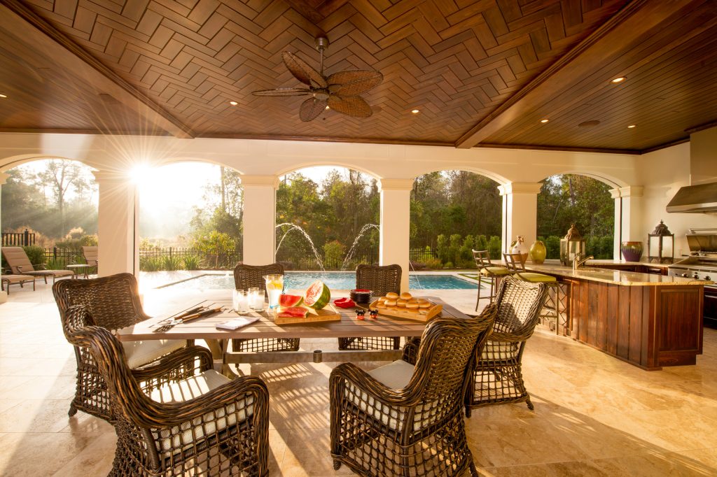 Patio kitchen - large mediterranean backyard stone patio kitchen idea in Orlando