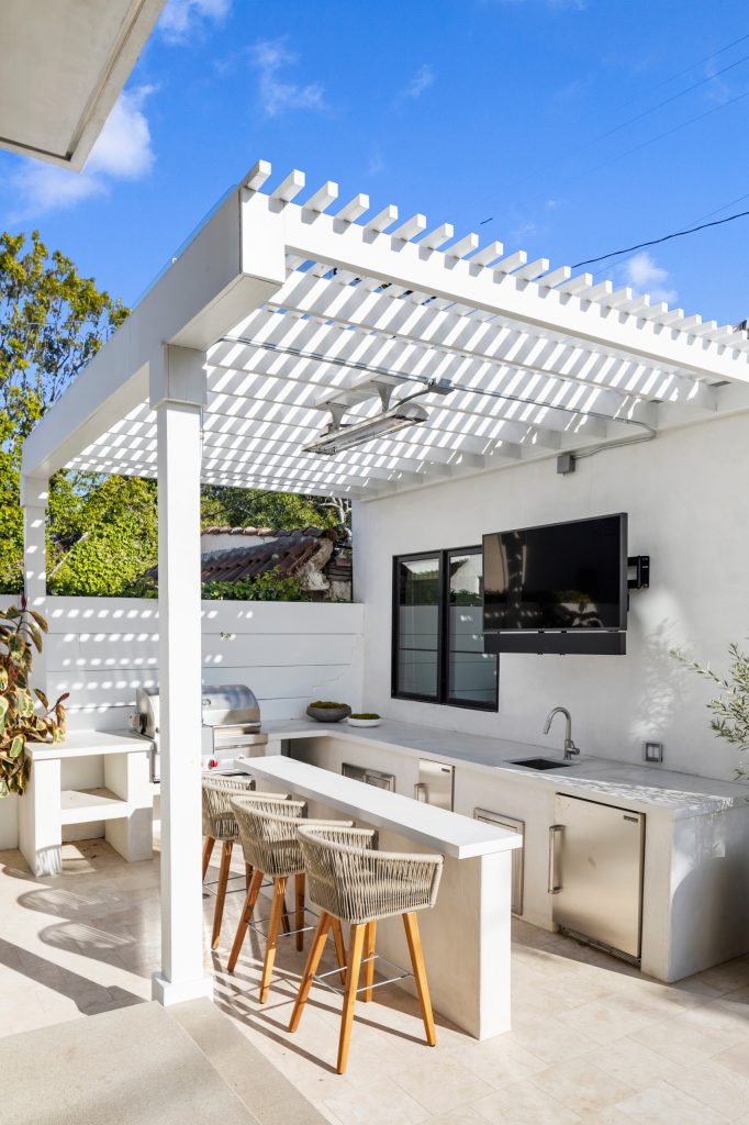 Patio kitchen - large mediterranean courtyard tile patio kitchen idea in Los Angeles with a pergola