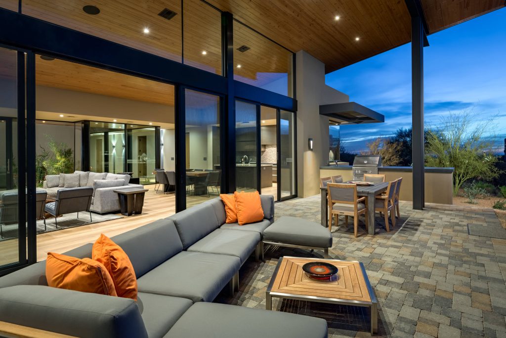Patio kitchen - large modern backyard brick patio kitchen idea in Phoenix with a roof extension