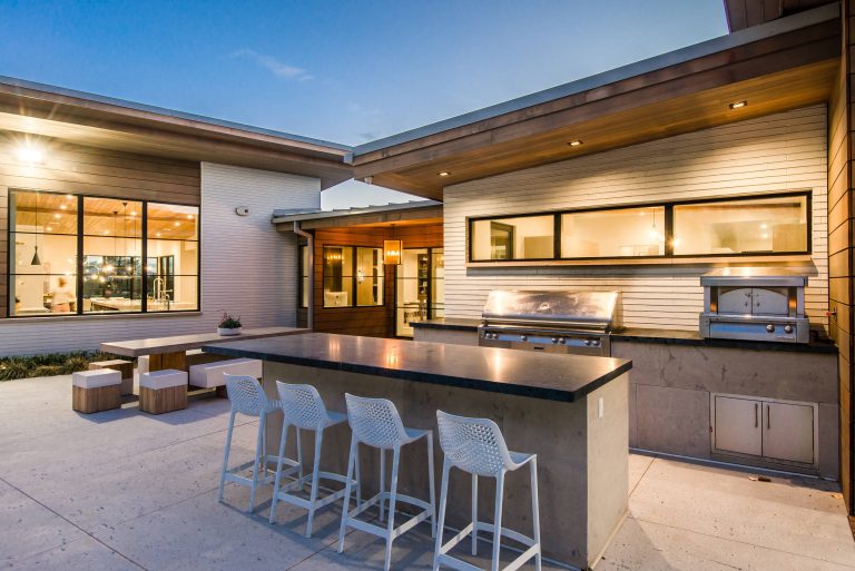 Patio kitchen - large modern backyard concrete patio kitchen idea in Salt Lake City with a roof extension