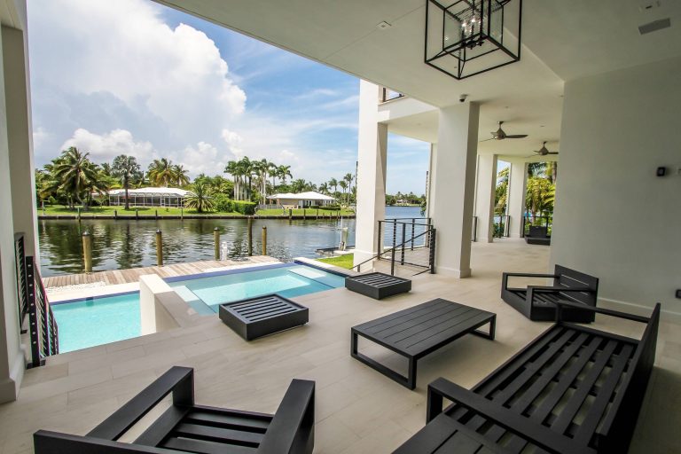 Patio kitchen - large modern backyard patio kitchen idea in Miami with a roof extension