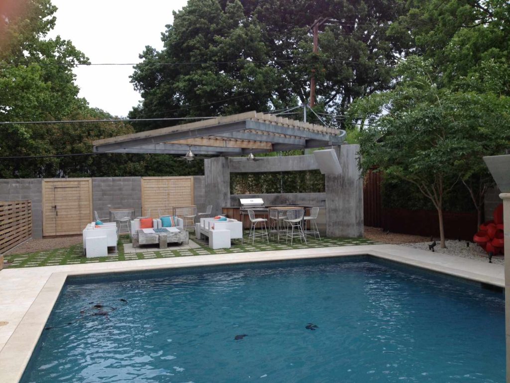 Patio kitchen - large modern backyard stone patio kitchen idea in Dallas with a pergola