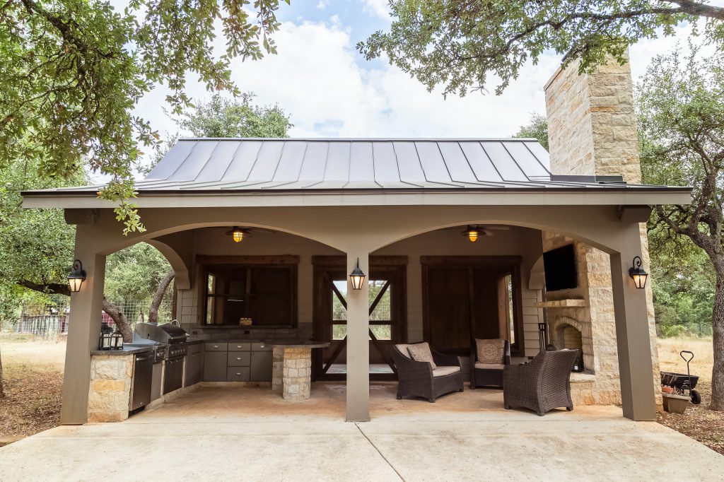 Patio kitchen - large rustic backyard concrete patio kitchen idea in Austin with a roof extension