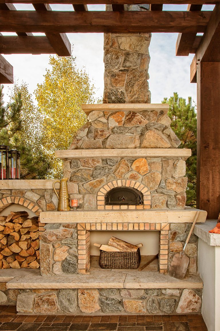 Patio kitchen - large rustic backyard concrete paver patio kitchen idea in Denver with a pergola