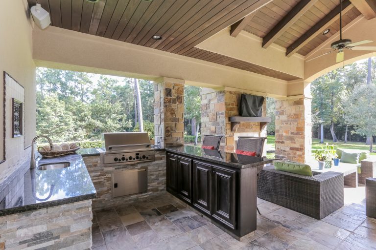 Patio kitchen - large rustic backyard tile patio kitchen idea in Houston with a roof extension