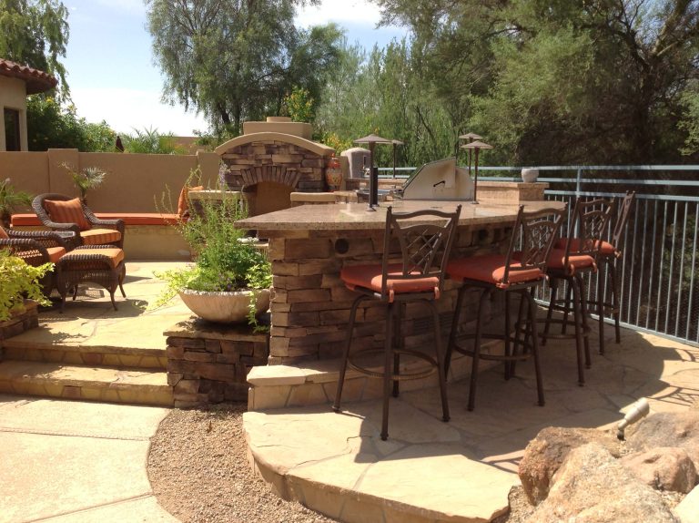 Patio kitchen - large southwestern backyard stone patio kitchen idea in Phoenix with no cover
