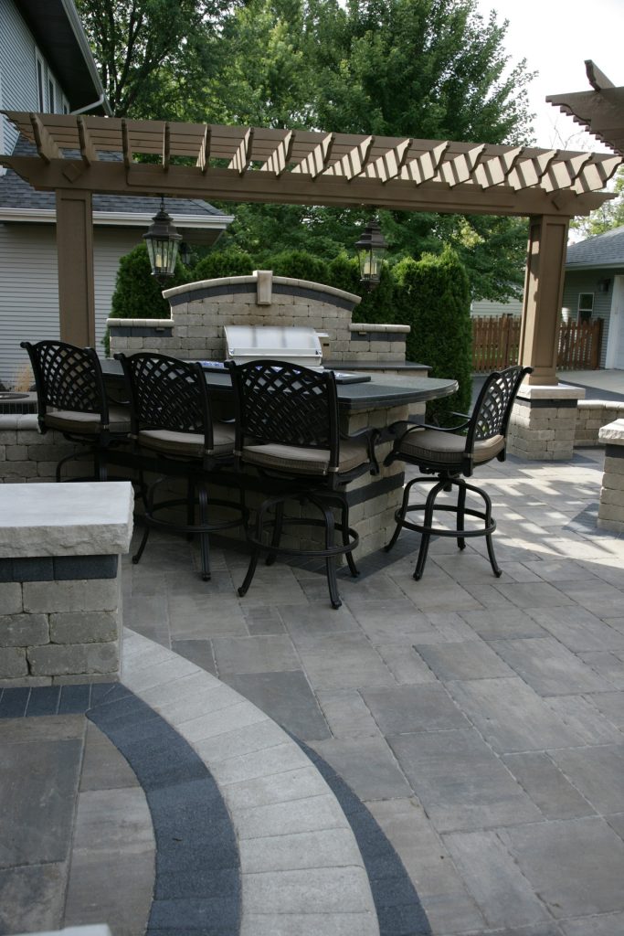 Patio kitchen - large traditional backyard brick patio kitchen idea in Chicago with a pergola