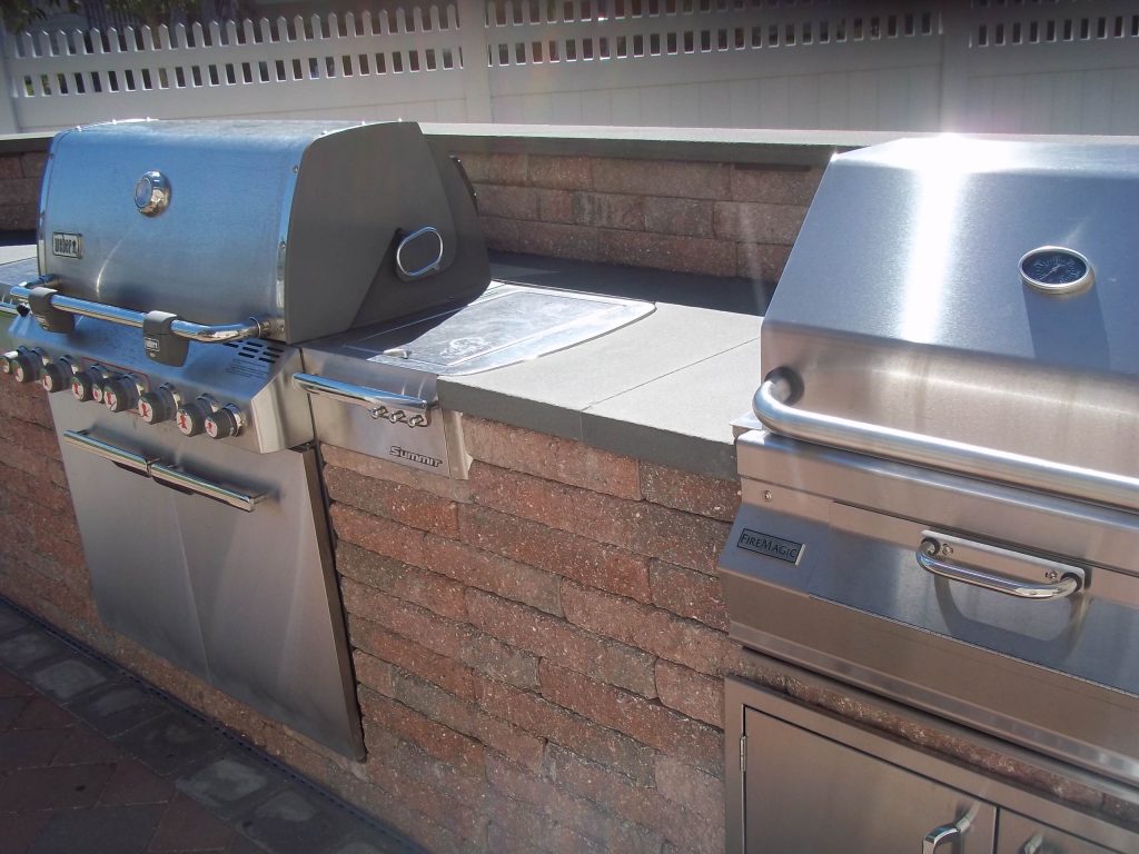Patio kitchen - large traditional backyard brick patio kitchen idea in New York with no cover