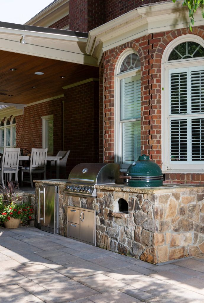Patio kitchen - large traditional backyard concrete paver patio kitchen idea in Charlotte with a roof extension