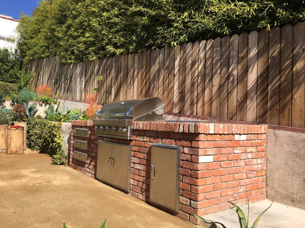 Patio kitchen - large traditional backyard gravel patio kitchen idea in Los Angeles with no cover