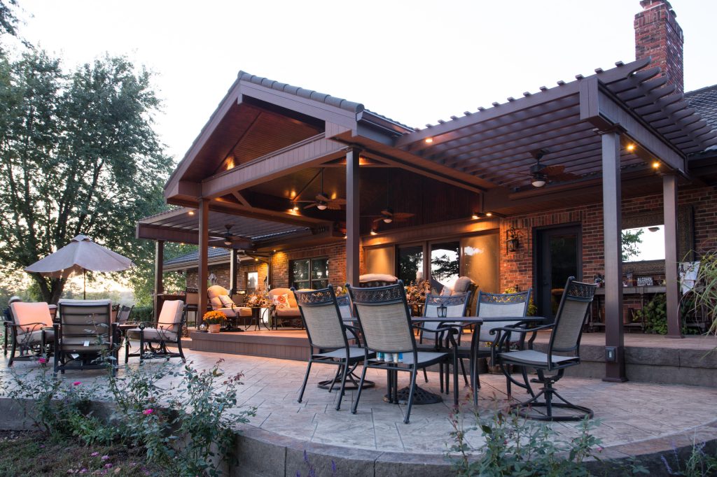 Patio kitchen - large traditional backyard stamped concrete patio kitchen idea in Kansas City with a pergola
