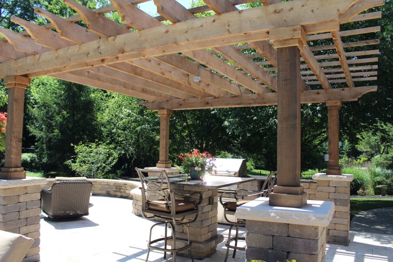 Patio kitchen - large traditional backyard stone patio kitchen idea in Indianapolis with a pergola