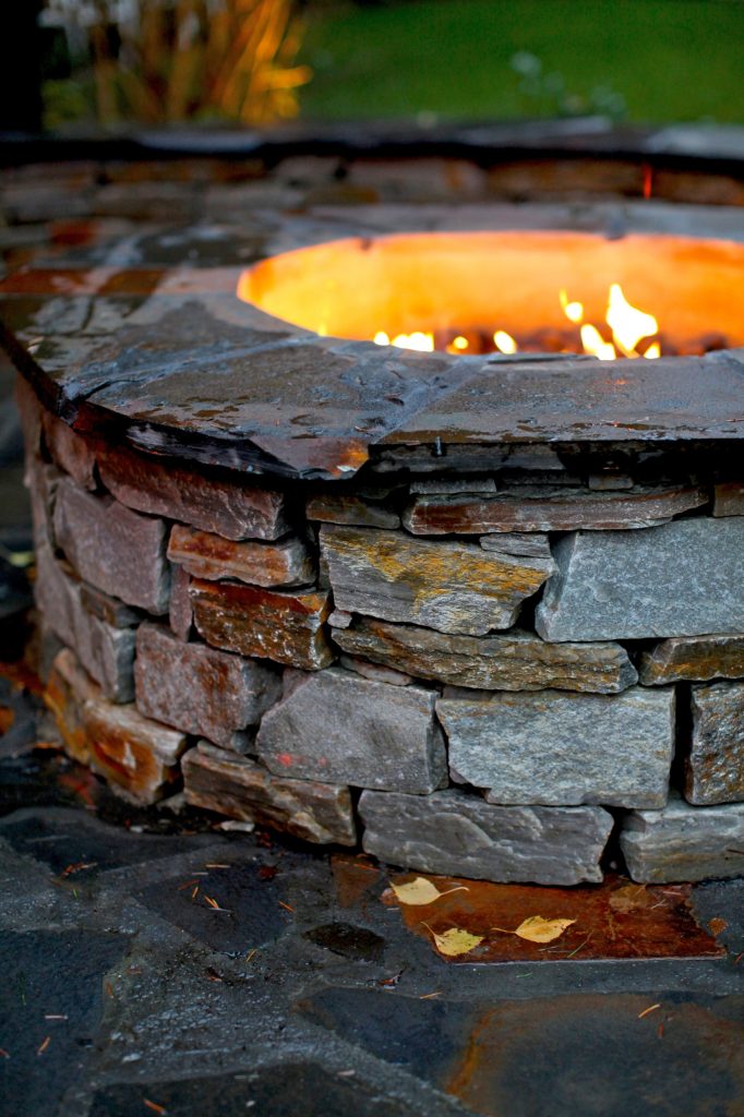 Patio kitchen - large traditional backyard stone patio kitchen idea in Seattle with a gazebo