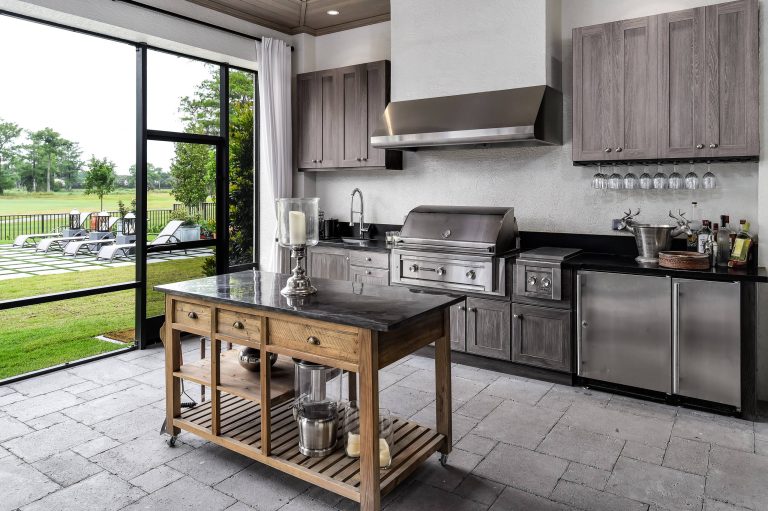 Patio kitchen - large transitional backyard concrete paver patio kitchen idea in Miami with a roof extension