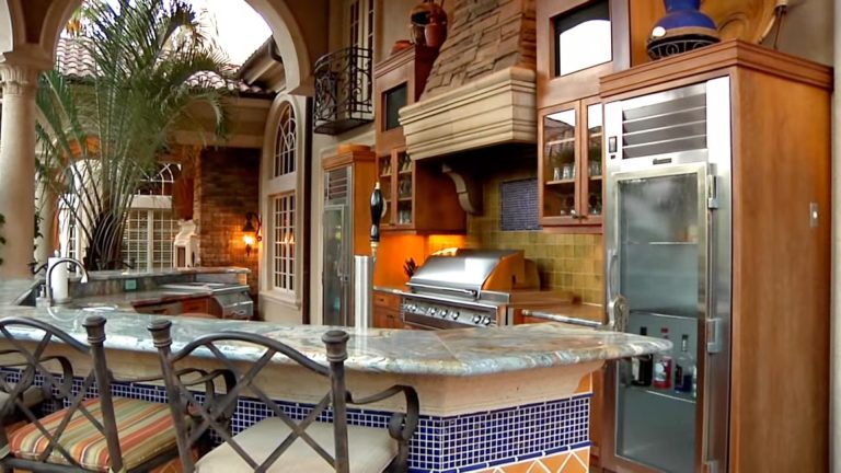 Patio kitchen - large tropical backyard patio kitchen idea in Tampa with a roof extension