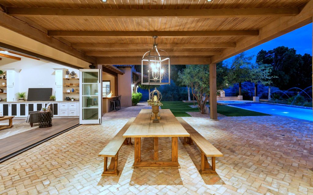Patio kitchen - mediterranean backyard brick patio kitchen idea in Phoenix with an awning