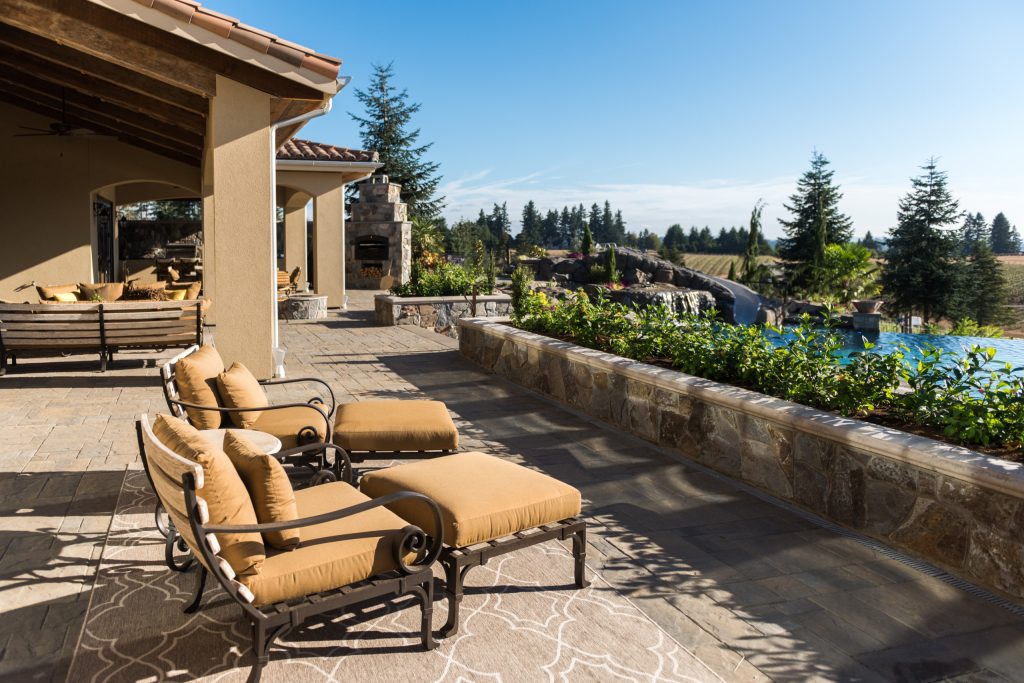 Patio kitchen - mediterranean backyard concrete paver patio kitchen idea in Portland with a roof extension